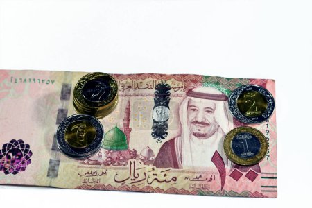 Photo for 100 SAR one hundred Saudi Arabia riyals cash money banknote with pile of Saudi riyal coins 1 and 2 riyals features king Salman Bin AbdulAziz Al Saud and King AbdulAziz, Saudi money exchange rate - Royalty Free Image