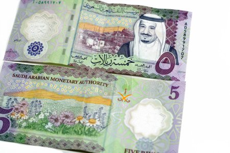 Photo for New polymer 5 SAR five Saudi Arabia riyals cash money banknote bill series 1441 AH features Shaybah oil refinery in Rub' al Khali, king Salman Bin AbdulAziz Al Saud and a field of flowers isolated - Royalty Free Image