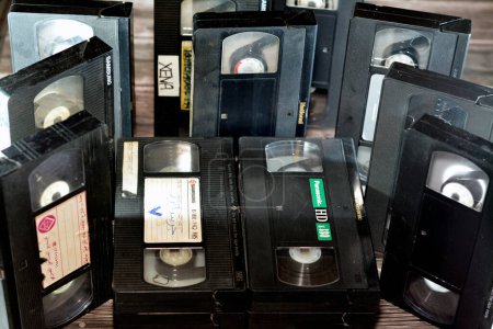 Foto de El Cairo, Egipto, 18 de octubre de 2022: pila de cintas de vídeo VHS con suministro y toma de carretes y de plástico que se utilizaron en grabadoras de vídeo, cintas de vídeo obsoletas vintage estilo retro - Imagen libre de derechos
