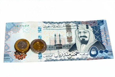 Photo for Obverse side of 500 SAR five hundred Saudi Arabia riyals cash money banknote features king AbdulAziz Al Saud and Kaaba with change of Saudi riyal coins 1 and 2 riyals, Saudi money exchange rate - Royalty Free Image