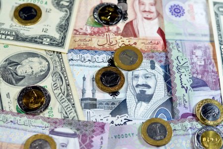 Photo for Background of American dollars cash money banknotes and coins with Saudi Arabia kingdom money bills and coins, Saudi and American currency exchange rates, oil and financial concept of middle east - Royalty Free Image