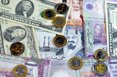 Photo for Background of American dollars cash money banknotes and coins with Saudi Arabia kingdom money bills and coins, Saudi and American currency exchange rates, oil and financial concept of middle east - Royalty Free Image