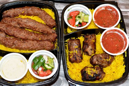 Photo for Arabic cuisine traditional food beef  Kofta, kebab and tarb kofta shish which is minced meat with Basmati rice, oriental grilled barbecued meat food with long yellow rice, selective focus - Royalty Free Image
