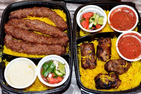 Photo for Arabic cuisine traditional food beef  Kofta, kebab and tarb kofta shish which is minced meat with Basmati rice, oriental grilled barbecued meat food with long yellow rice, selective focus - Royalty Free Image