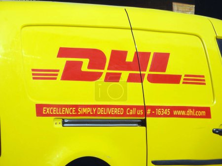 Photo for Cairo, Egypt, December 7 2022: DHL truck delivering a package, DHL is the global leader in the logistics industry specializing in international shipping, courier services and transportation - Royalty Free Image