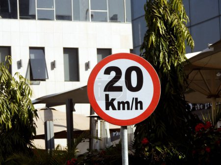 Photo for Cairo, Egypt, December 10 2022: A road sign of 20 KMH twenty Kilometers per hour speed limit in the slow lane near gateway, restaurants and cafes, Prohibitory traffic Speed limit zone sign - Royalty Free Image