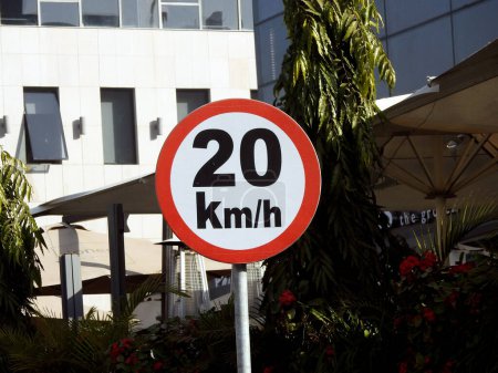 Photo for Cairo, Egypt, December 10 2022: A road sign of 20 KMH twenty Kilometers per hour speed limit in the slow lane near gateway, restaurants and cafes, Prohibitory traffic Speed limit zone sign - Royalty Free Image