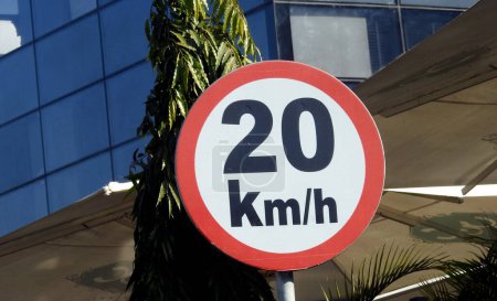 Photo for A road sign of 20 KMH twenty Kilometers per hour speed limit in the slow lane near gateway, restaurants and cafes, Prohibitory traffic Speed limit sign, speed limit zone in Egypt, selective focus - Royalty Free Image