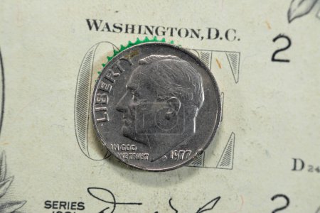 Foto de La moneda de diez centavos, moneda de dinero estadounidense de 10 centavos 1977 presenta el perfil de Franklin D. Roosevelt, el 32º presidente de los Estados Unidos de América, moneda retro vintage de los Estados Unidos de América en el billete de USD - Imagen libre de derechos