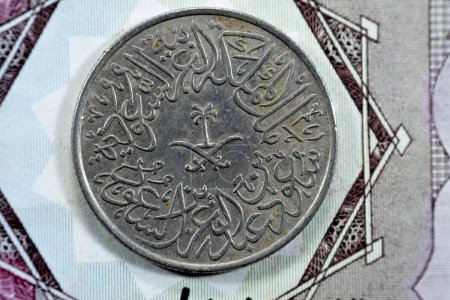 Photo for Crossed swords and palm tree at center of obverse side of old Saudi Arabia two piaster 10 ten halalah coin 1379 AH, Translation of Arabic (King Saud Bin AbdulAziz Al Saud), vintage retro old coin - Royalty Free Image