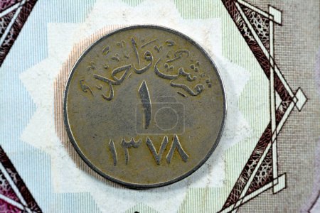 Photo for Translation of Arabic (One Piaster 1378) from the reverse side of an old Saudi Arabia one piastre 5 five Halalah coin, vintage retro old Saudi money coin, selective focus - Royalty Free Image