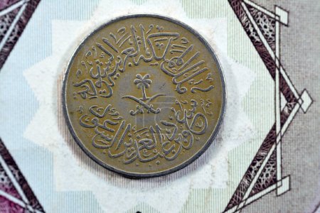 Photo for Crossed swords and palm tree at center of obverse side of old Saudi Arabia One piaster 5 five halalah coin 1378 AH, Translation of Arabic (King Saud Bin AbdulAziz Al Saud), vintage retro old coin - Royalty Free Image