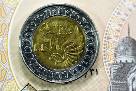 Téléchargez les photos : Obverse side of Egyptian 1 LE EGP One Egyptian pound coin on Egyptian banknote, Translation of Arabic (Police day 69 years) in the memorial of Egypt police day with a flying falcon - en image libre de droit