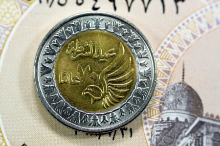 Photo for Obverse side of Egyptian 1 LE EGP One Egyptian pound coin on Egyptian banknote, Translation of Arabic (Police day 70 years) in the memorial of Egypt police day with a flying falcon - Royalty Free Image