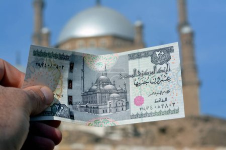 Téléchargez les photos : The great mosque of Muhammad Ali Pasha or Alabaster mosque in Citadel of Cairo from the obverse side of 20 LE twenty Egyptian pounds money banknote and the real mosque blurred in background - en image libre de droit