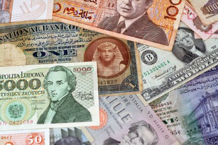 Foto de Various old cash money banknotes from different countries of the world, stack of multiple currencies, pile of vintage retro bills of different origins with profiles of country leaders, ancient money - Imagen libre de derechos