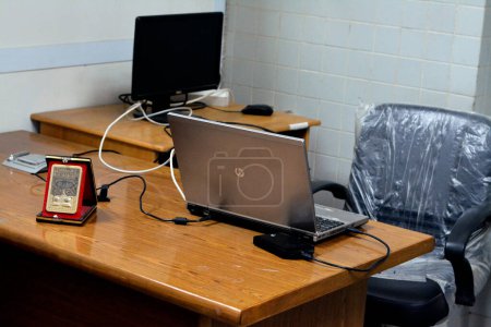 Téléchargez les photos : Le Caire, Égypte, 11 février 2023 : Un lieu de travail simple avec bureau en bois et chaise de bureau hydraulique, avec ordinateur de bureau Dell et ordinateur portable Hp, bureau d'affaires simple, foyer sélectif - en image libre de droit