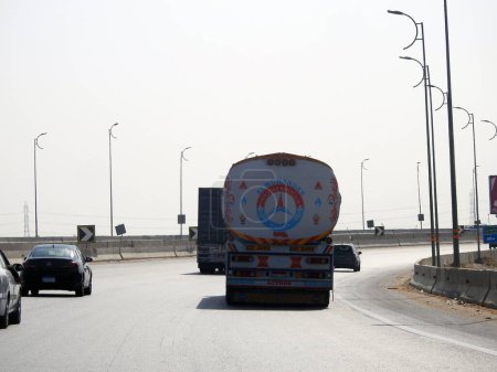 Téléchargez les photos : Gizeh, Egypte, 9 mars 2023 : Un grand camion avec un réservoir de conteneurs avec des produits pétroliers, un camion sur l'autoroute avec un conteneur sur elle livrant les produits pour un usage industriel, foyer sélectif - en image libre de droit