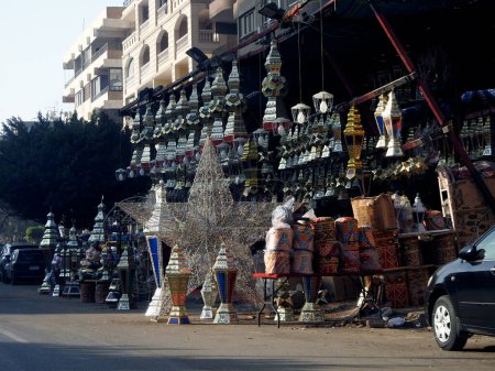 Photo for Cairo, Egypt, March 11 2023: The Festive events in Egyptian streets before Ramadan Fasting month of Muslims with lots of lanterns, lamps, khayamiya, fanous, fanos, crescents, stars, iftar cannon decor - Royalty Free Image