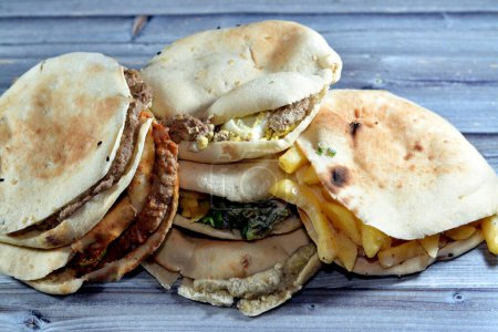 Foto de Sándwiches tradicionales egipcios de puré de habas, huevos cocidos, dedos de papas fritas, picante alejandrino, sándwich de Baba Ghanoush, papas con Tahini en pan sirio Shami - Imagen libre de derechos