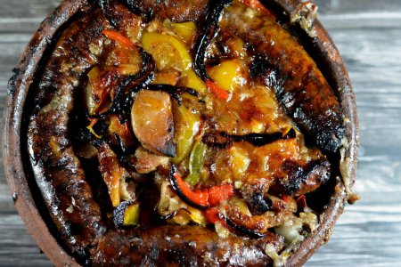 Photo for Traditional Egyptian mixture of lamb meat, sausage mumbar intestines filled with rice, kawareh trotters cow feet, pieces of cooked kidneys, hearts and testicles in a pottery casserole cooked in oven - Royalty Free Image