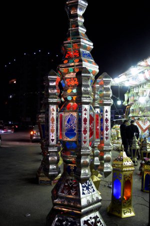 Foto de El Cairo, Egipto, 20 de marzo de 2023: Los eventos festivos en las calles egipcias antes del Ramadán El mes de ayuno de los musulmanes con grandes linternas, lámparas, khayamiya, fanáticos, fanos, semilunas, estrellas, decoración de cañones de iftar - Imagen libre de derechos