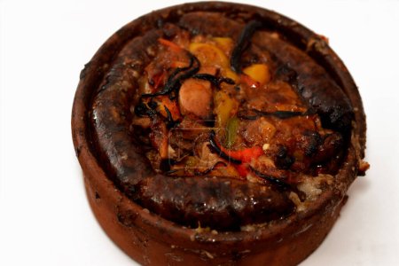 Photo for Traditional Egyptian mixture of lamb meat, sausage mumbar intestines filled with rice, kawareh trotters cow feet, pieces of cooked kidneys, hearts and testicles in a pottery casserole cooked in oven - Royalty Free Image