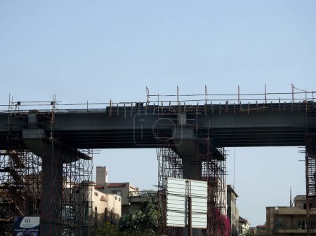 Foto de El Cairo, Egipto, 18 de abril de 2023: sitio de monorraíl de El Cairo que está en construcción por la compañía Orascom con las columnas y las vías en la ciudad de Nuevo Cairo, sistema de tránsito rápido, conductor más largo menos monorraíl - Imagen libre de derechos