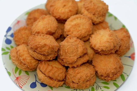 Téléchargez les photos : Une pile de biscuits arabes traditionnels pour célébrer les fêtes islamiques de la fête d'El-Fitr, petite boulangerie quatre (mignardises) farcie avec de la confiture, une petite confiserie en forme de bouchée ou un apéritif salé - en image libre de droit