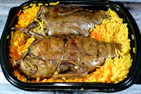 Photo for Egyptian Hamam Mahshi stuffed squab, Arabic cuisine, Egyptian traditional stuffed pigeon dish filled with rice and Freekeh cracked green wheat grains, oriental roasted pigeons meal with Basmati rice - Royalty Free Image