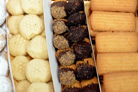 Téléchargez les photos : Biscuits arabes traditionnels pour la célébration des fêtes islamiques Fête d'El-Fitr, Ghoriba égyptienne, Kahk égyptien au sucre en poudre, petits quatre (mignardises) au chocolat et biscuits égyptiens de l'Aïd - en image libre de droit