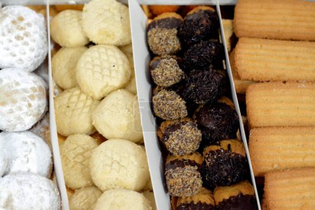 Téléchargez les photos : Biscuits arabes traditionnels pour la célébration des fêtes islamiques Fête d'El-Fitr, Ghoriba égyptienne, Kahk égyptien au sucre en poudre, petits quatre (mignardises) au chocolat et biscuits égyptiens de l'Aïd - en image libre de droit