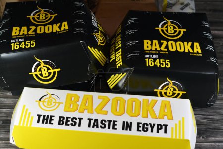 Téléchargez les photos : Le Caire, Egypte, 30 avril 2023 : Bazooka fast food package de hamburgers de poulet, fajita wraps, frites et boissons gazeuses, Bazooka est un restaurant situé en Egypte, servant une sélection de Burgers - en image libre de droit
