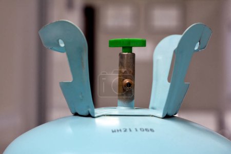 Téléchargez les photos : Une bouteille de gaz de fréon remplie de gaz incolore à température ambiante, ininflammable, incolore, un réfrigérant utilisé dans le système automatique de climatisation et de réfrigération, la vanne de bouteille et le tube - en image libre de droit