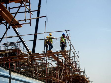 Foto de El Cairo, Egipto, 10 de mayo de 2023: ingenieros y trabajadores en una obra de construcción con andamios y grúas móviles en uno de los nuevos proyectos de la nueva finca de Egipto, nuevos proyectos de desarrollo en El Cairo - Imagen libre de derechos