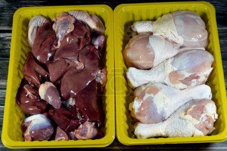 Photo for Raw chicken legs drumsticks hindquarter with skin and bones and fresh uncooked chicken livers, gizzards and hearts, selective focus of fresh liver, gizzard and heart of chickens full of protein - Royalty Free Image