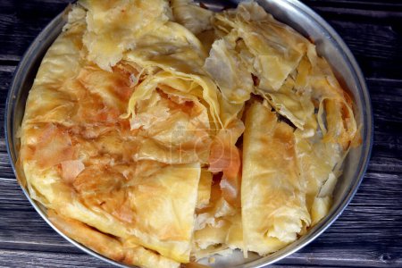Photo for Egyptian Feteer meshaltet, layers upon layers of pastry dough with loads of ghee or butter in between, one of the famous Egyptian pastry recipes, a flaky Egyptian layered pastry bread dough and butter - Royalty Free Image