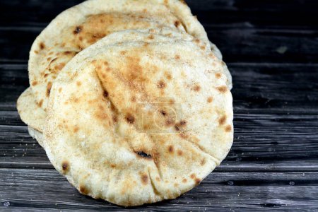 Photo for Traditional Egyptian flat bread with wheat bran and flour, regular Aish Baladi or Egypt bread baked in extremely hot ovens, it is the result of a mixture of wheat flour, yeast, salt and water - Royalty Free Image