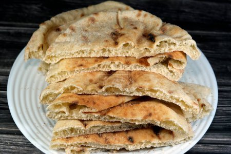 Photo for Traditional Egyptian flat bread with wheat bran and flour, regular Aish Baladi or Egypt bread baked in extremely hot ovens, it is the result of a mixture of wheat flour, yeast, salt and water - Royalty Free Image