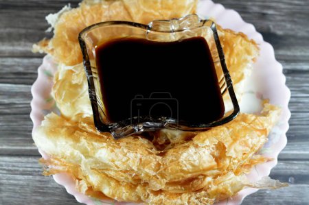 Photo for Egyptian Feteer meshaltet, layers upon layers of pastry dough with loads of ghee or butter in between with Molasses, a viscous substance resulting from refining sugarcane or sugar beets into sugar - Royalty Free Image