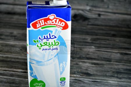Photo for Cairo, Egypt, May 30 2023: MilkyLand full cream fresh cow's milk carton bottle of 1 one Liter litre, selective focus of Milky Land natural milk isolated on wooden background - Royalty Free Image