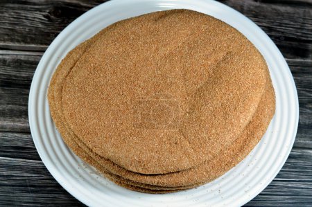 Photo for Brown baked pitta bread flatbread made mainly in bran, Bran breads used for sandwiches and beside meals, popular in Egypt, brown circular and round baked bran breads, selective focus - Royalty Free Image