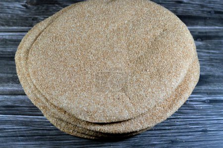Photo for Brown baked pitta bread flatbread made mainly in bran, Bran breads used for sandwiches and beside meals, popular in Egypt, brown circular and round baked bran breads, selective focus - Royalty Free Image