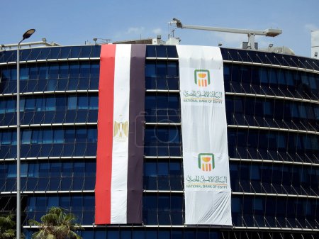 Cairo, Egypt, June 29 2023: The Exterior of the National bank of Egypt Al Ahly Egyptian bank with the ban flag and the Egyptian flag celebrating the anniversary of the bank 125 years