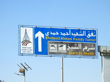 Téléchargez les photos : Itinéraire de De martyr Shaheed Ahmed Hamdy Tunnel et Sharm El Sheikh Shaikh ville sur un panneau de signalisation routière latérale informative à la route du tunnel et Sharm, foyer sélectif - en image libre de droit