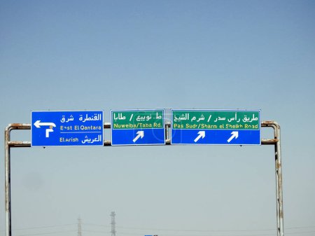 Téléchargez les photos : Un panneau de signalisation latérale de direction dans le sud du Sinaï donne des directions de Sharm El Sheikh, Ras Sudr ville, East Qantara, El Arish et Nuweiba Taba Road, foyer sélectif du conseil directionnel - en image libre de droit