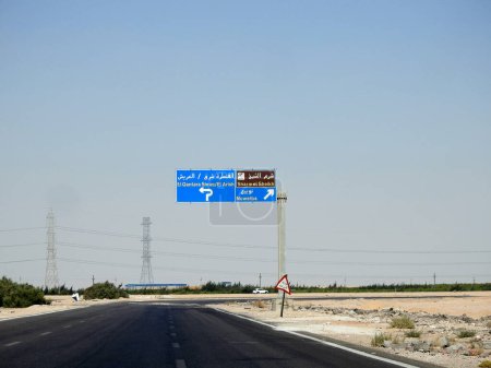Téléchargez les photos : Sinaï Sud, Egypte, 30 Juin 2023 : un panneau de direction dans le Sinaï Sud donne des directions de Charm El Sheikh, Qantara Est, villes d'Arish et Nuweiba sur l'autoroute écrite en arabe et en anglais - en image libre de droit