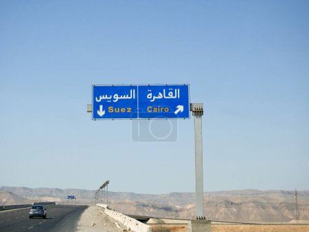 Téléchargez les photos : Un panneau routier avant l'autoroute du Caire de Suez donne la direction de la ville du Caire et du gouvernorat de Suez, panneau routier latéral en métal de la circulation pour les directions - en image libre de droit
