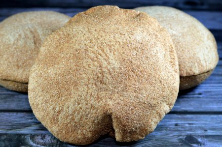 Photo for Egyptian brown bran thin crispbread bread, puff thin, crispy and delicious, eaten alone or with anything, brown circular, crunch and round baked bran whole grain breads, selective focus - Royalty Free Image