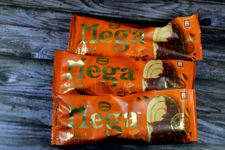 Photo for Cairo, Egypt, July 15 2023: Nestle Mega Salted Caramel ice cream stick coated and covered with a layer of dark chocolate with nuts, Rich flavored ice cream in cracking chocolate crunch, roasted almond - Royalty Free Image